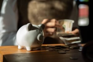 Cómo guardar dinero en casa y cumplir con las reglas del SAT 4 alcancia y manos contando billetes