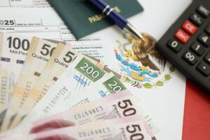 Cuánto te descuentan de impuestos en el aguinaldo en México 1 billetes mexicanos y calculadora sobre mesa