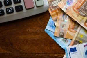 calculadora y billetes en mesa de madera