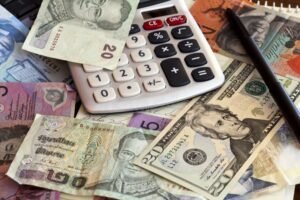 calculadora y billetes mexicanos sobre escritorio