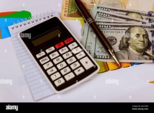 dinero y calculadora sobre mesa de oficina