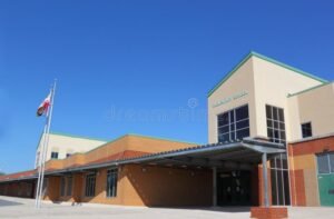 edificio institucional con bandera nacional y cielo azul