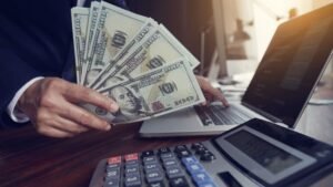 mano con billetes y calculadora financiera