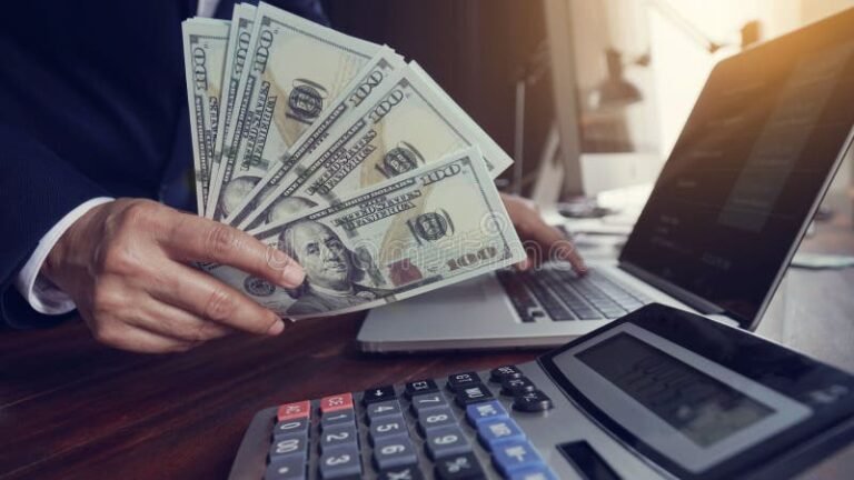 mano con billetes y calculadora financiera