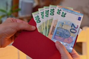 Cuánto se Da de Aguinaldo por un Año en México Según la Ley 2 mano entregando billetes de aguinaldo