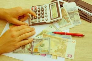 Qué Puedo Deducir de Impuestos Para Ahorrar Dinero 3 manos calculando finanzas con calculadora y dinero 1