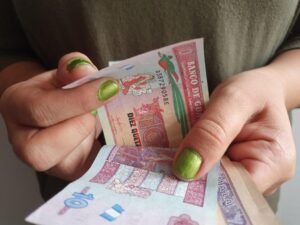 manos contando billetes mexicanos y calendario