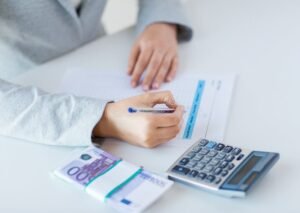 manos contando dinero con calculadora impuestos