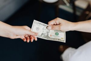 manos entregando dinero con contrato cercano