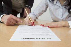 Qué Son Las Prestaciones De Ley En Un Trabajo Y Por Qué Son Importantes 1 manos firmando contrato laboral con empleados