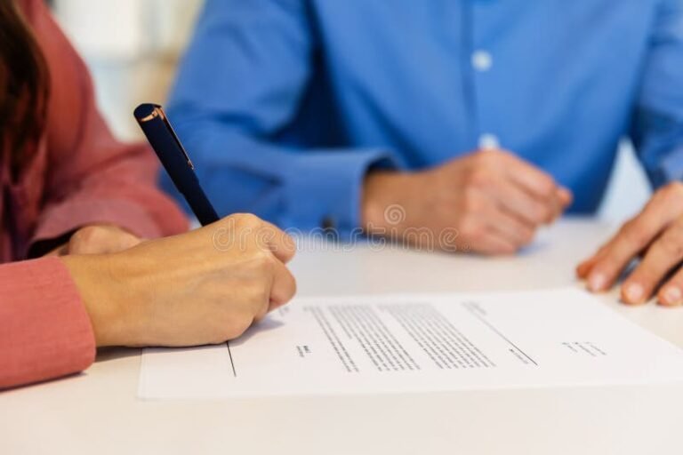 manos firmando contrato laboral en oficina