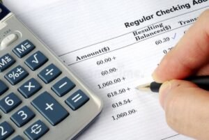 manos revisando extracto bancario y calculadora