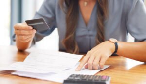 manos revisando informe crediticio y calculadora