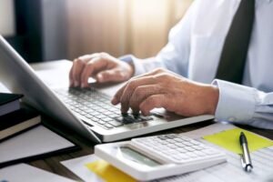 manos trabajando con calculadora y documentos laborales