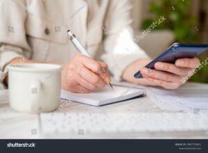 persona anotando finanzas personales en libreta