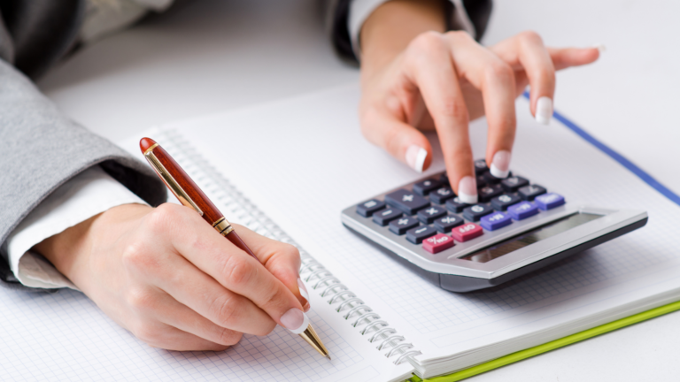 persona calculando finiquito con calculadora y documentos