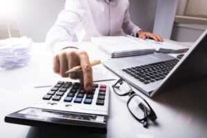 Cómo Calcular el ISR de Mi Sueldo Paso a Paso en México 3 persona calculando impuestos con calculadora y laptop