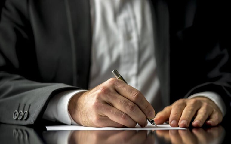 persona escribiendo nota de remision papel