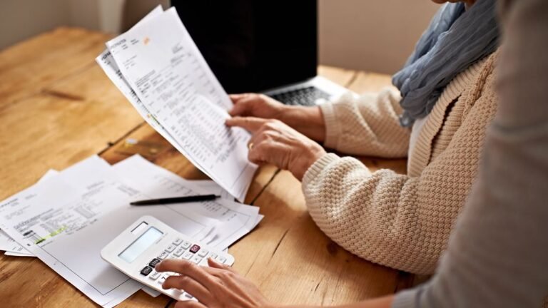 persona llenando formulario fiscal con documentos