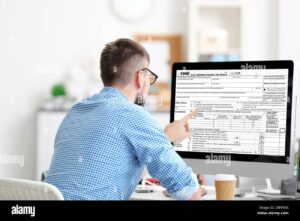 persona llenando formulario fiscal en escritorio