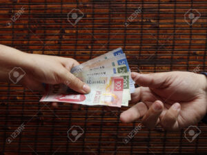 persona recibiendo pago con billetes mexicanos