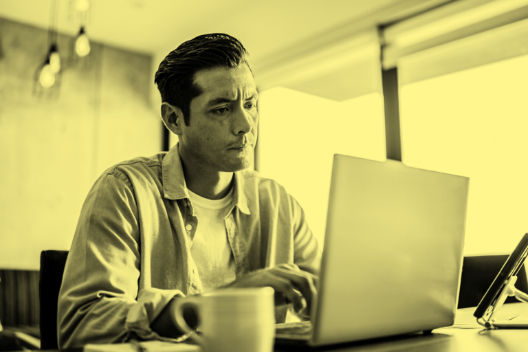 persona reflexionando frente a computador y documentos