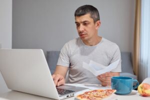 Cómo puedo verificar si el SAT me debe dinero o un saldo a favor 5 persona revisando comprobantes fiscales en laptop