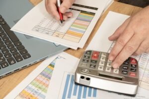 Cómo Saber Si Tienes Deudas Pendientes Con El SAT En México 30 persona revisando cuentas con calculadora y documentos