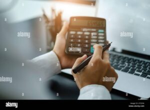 Cómo puedo consultar cuánto debo al SAT de manera sencilla 6 persona revisando cuentas con calculadora y laptop