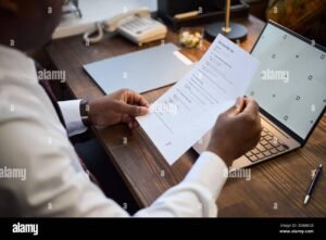 persona revisando documentos frente a computadora