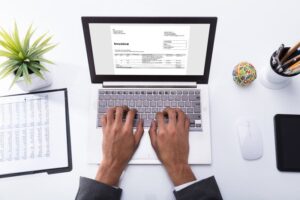 persona revisando facturas en computadora portatil