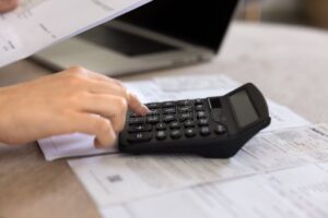 Qué gastos puedes deducir como persona física con actividad empresarial 3 persona revisando facturas y calculadora economica