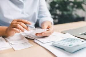 persona revisando recibos y calculadora financiera
