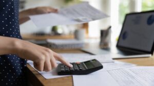 persona trabajando con facturas y calculadora