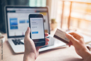 Cómo Funciona PayPal para Empresas en México y Cuáles Son Sus Beneficios 1 persona usando computadora y telefono movil pago digital