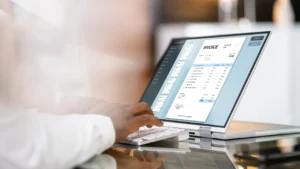 Cómo Consultar Facturas Electrónicas Recibidas de Forma Fácil 4 persona usando laptop y revisando facturas electronicas