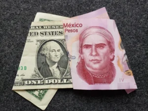 reloj y billetes mexicanos sobre escritorio laboral