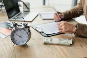 El día de descanso se paga y cómo calcularlo correctamente 1 reloj y dinero junto a documentos laborales